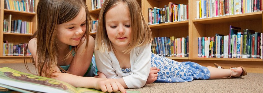 flickor läser på bibliotek