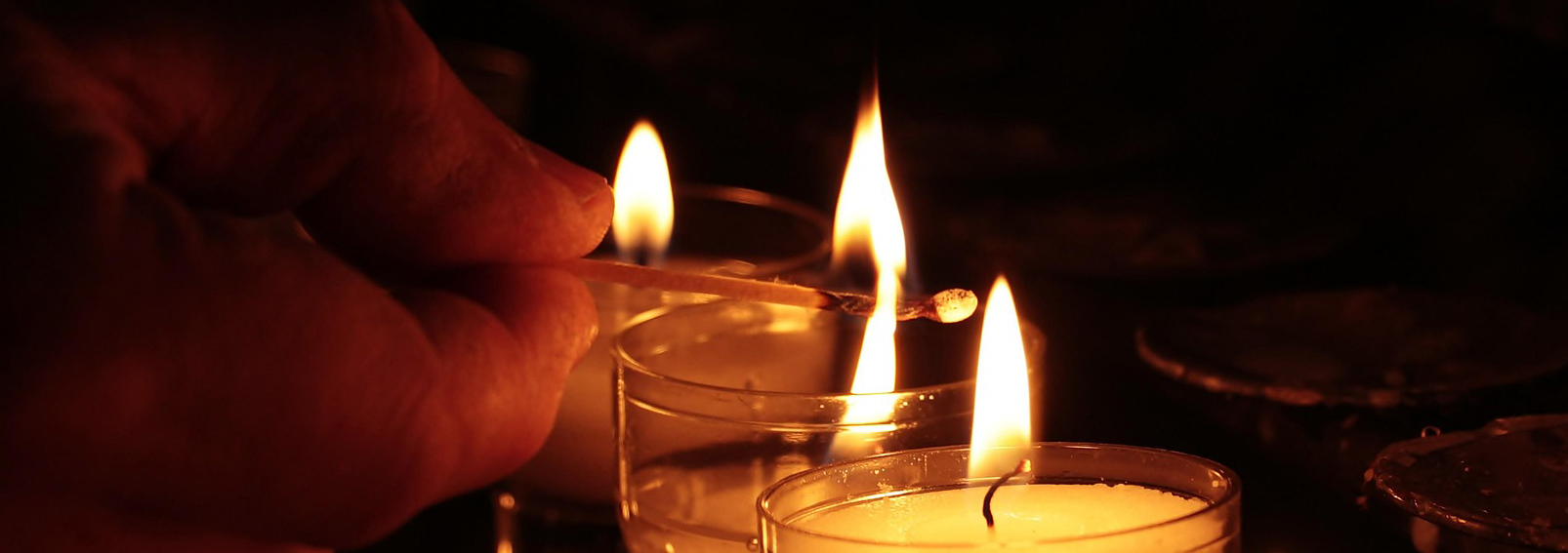 hand som tänder ljus