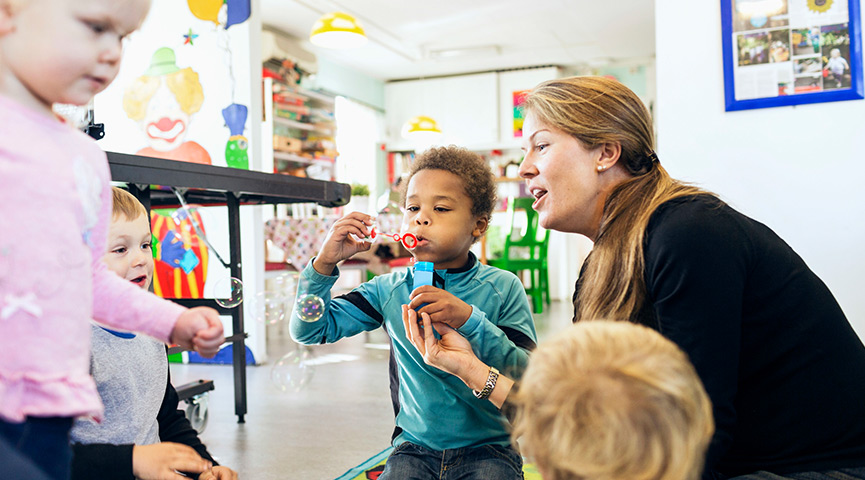 En förskolelärare lär ut hur man blåser såpbubblor