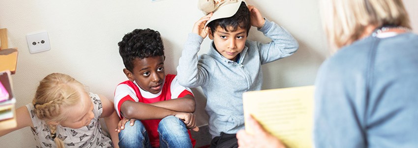En förskolelärare har högläsning för fyra barn