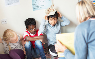 En förskolelärare har högläsning för fyra barn