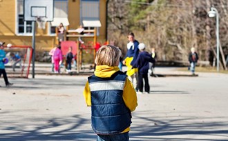 En elev står ensam på en skolgård