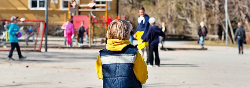 En elev står ensam på en skolgård