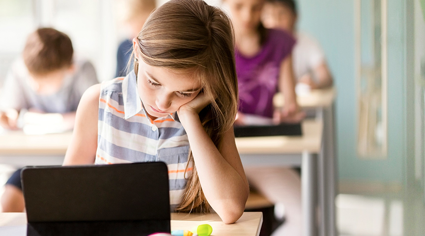 En elev sitter fokuserad under en lektion och studerar