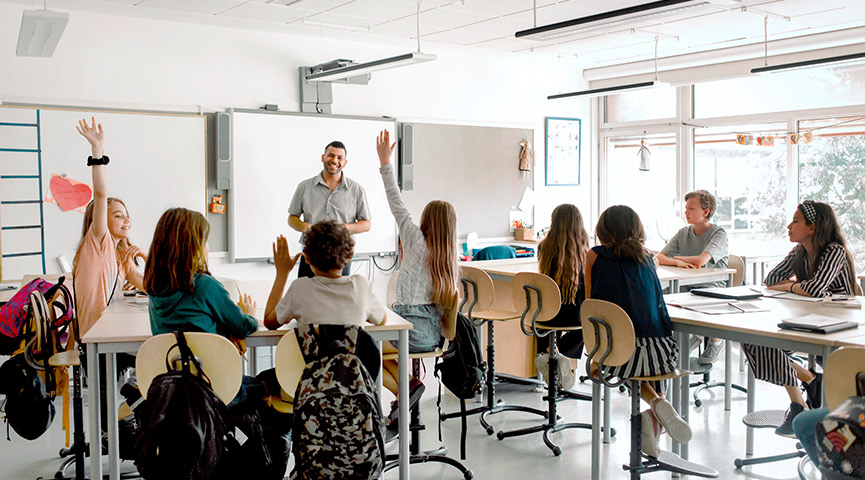 En lärare står och undervisar en mellanstadieklass i ett klassrum