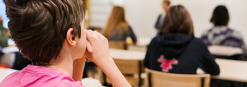 En högstadieklass lyssnar under en lektion 