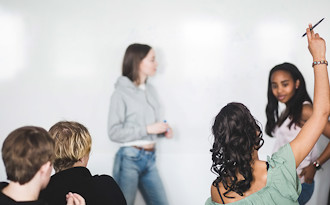 Tre elever håller redovisning för en liten grupp elever