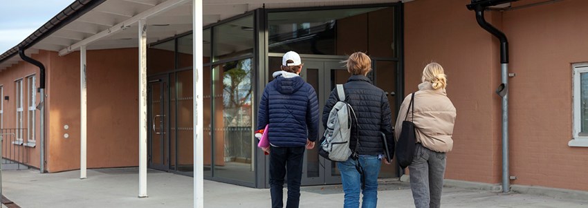Elever promenerar mot en skola