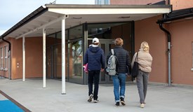 Elever promenerar mot en skola