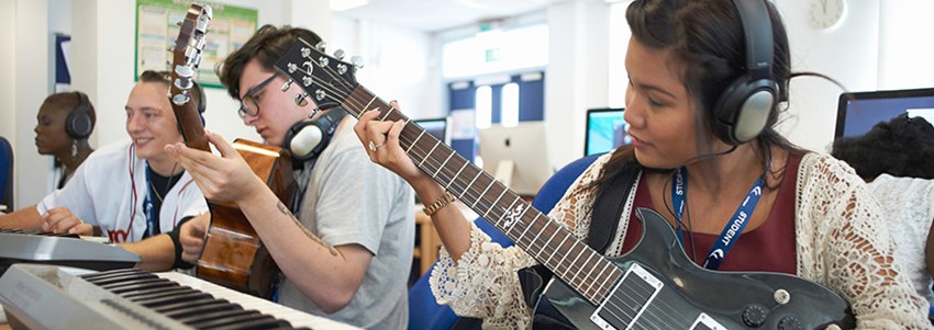 En musiklektion i gymnasiet där eleverna spelar gitarr och keyboard