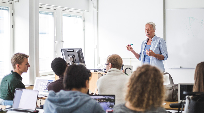 En lektion på gymnasiet. Elever sitter i bänkar och läraren undervisar.