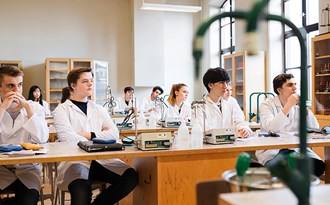 En gymnasieklass sitter och lyssnar under en lektion i kemi