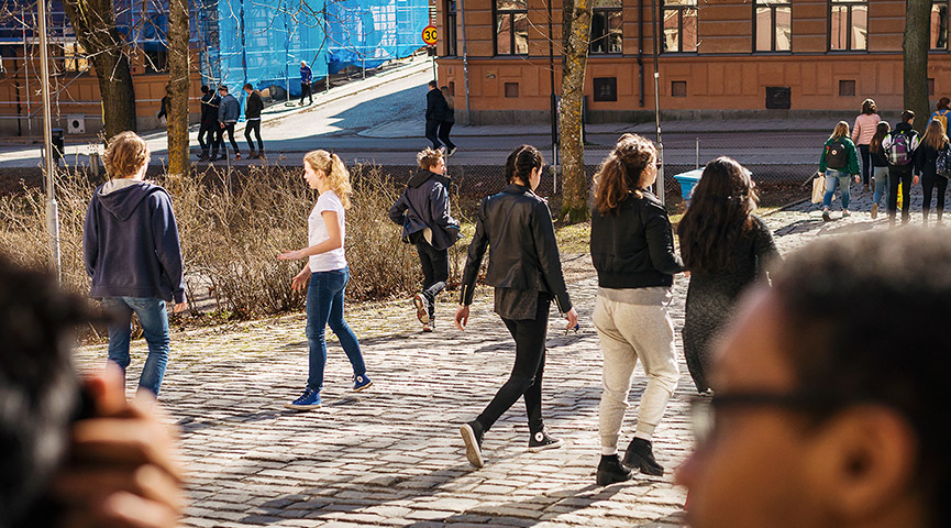 Gymnasieelever går utomhus i solen