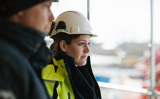Vuxenelev i byggkläder och hjälm 