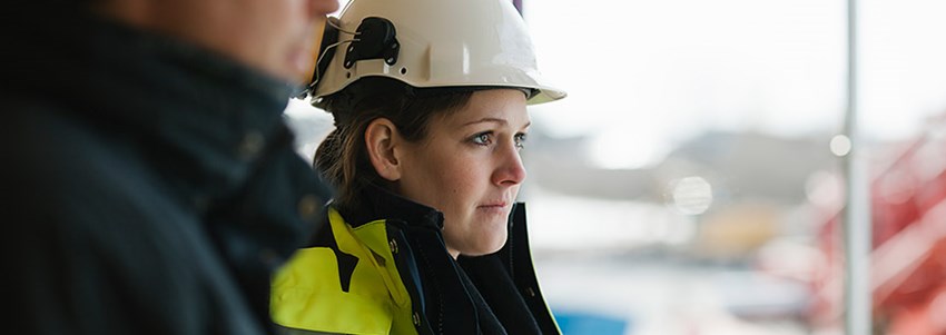 Kvinna med skyddshjälm och arbetskläder
