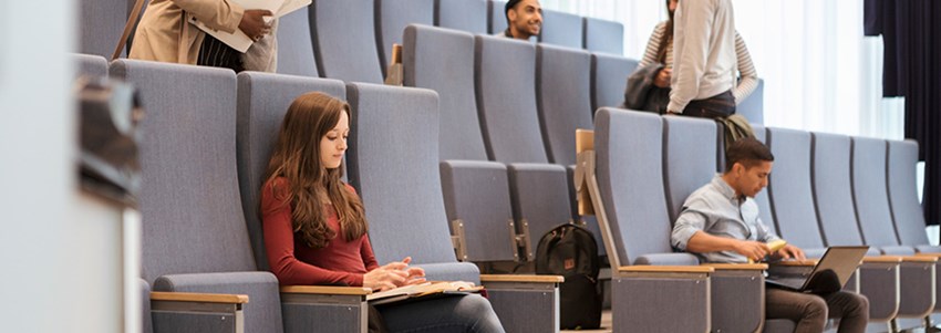 En liten klass sätter sig i hörsal