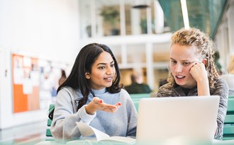 Två vuxenstudenter studerar tillsammans vid en dator