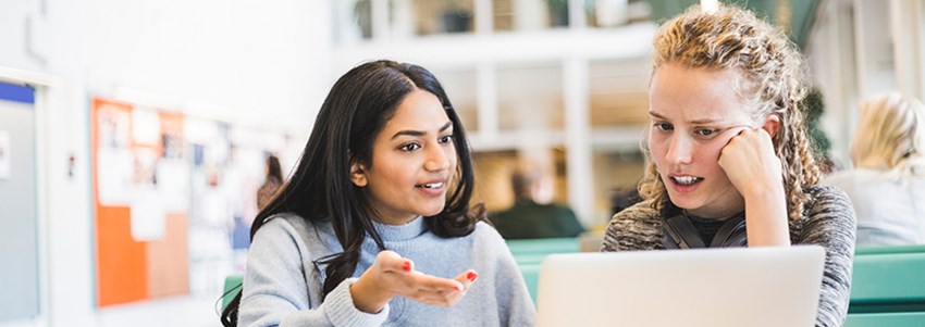 Två vuxenstudenter studerar tillsammans vid en dator