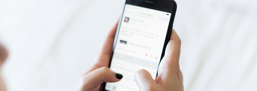 Två händer skriver på en mobiltelefon